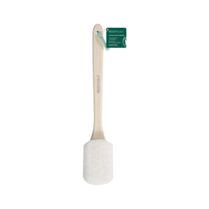 Loofah bath brush with white scrub head and light wood handle, green tag