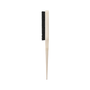 Slick back brush side view: cream handle with short black bristle pad