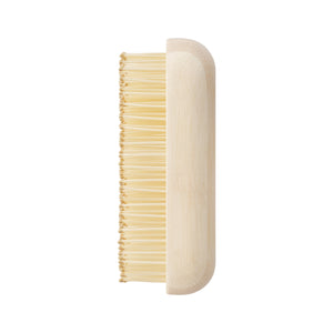 Light tan side view travel detangling brush with dense bamboo bristle rows