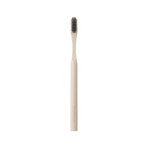 Edge defining brush with light bamboo handle and dark bristles, front view