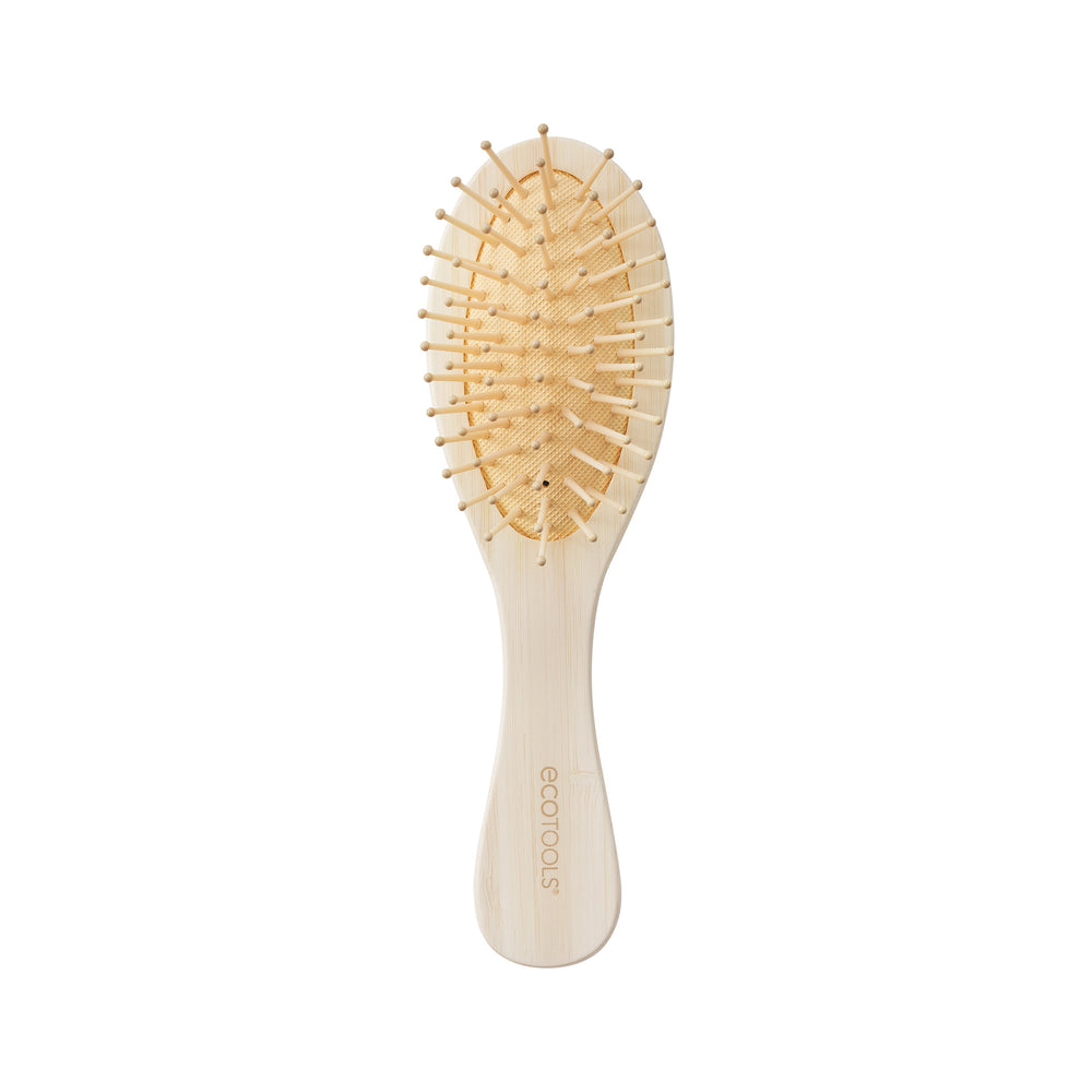 Mini detangler hair brush with oval wooden pad and light bamboo handle