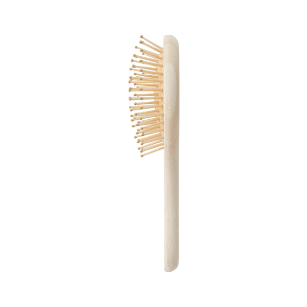 Mini detangler hair brush, side view of light bamboo handle and round pin head