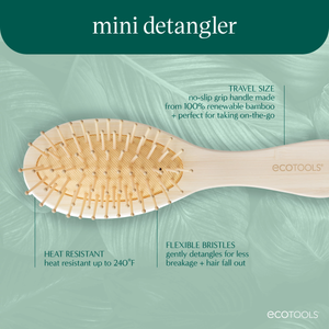 Mini detangling brush with oval bamboo paddle and flexible bristles, light wood handle