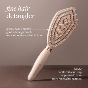 Fine hair detangler paddle brush angled view, light wood handle with gold-toned bristles