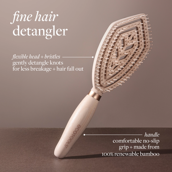 Fine hair detangler paddle brush angled view, light wood handle with gold-toned bristles