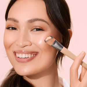Fresh face makeup brush applying makeup on the cheek near the eye