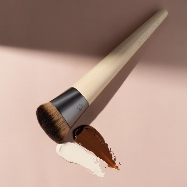 Foundation brush showing beige handle and brown bristles with product smear