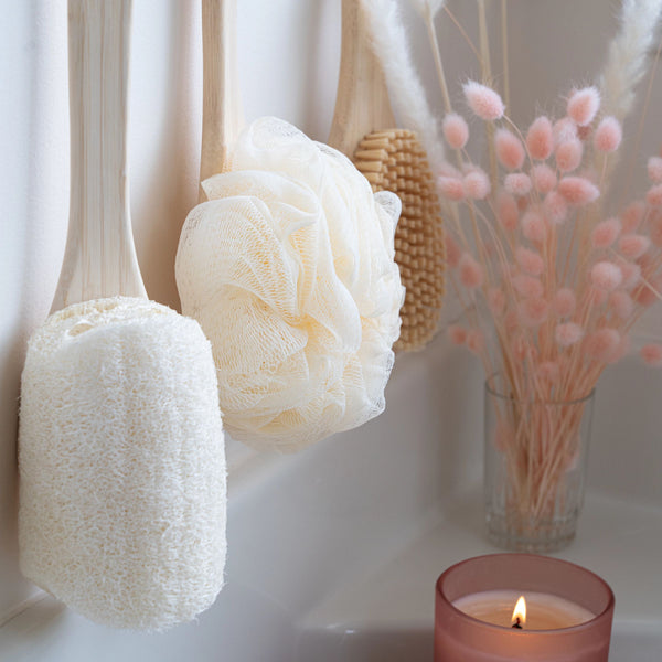 Ivory loofah bath brush head on bamboo handle used on wet skin