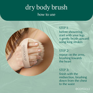 Hand using a dry body brush with a wood handle and bristle head