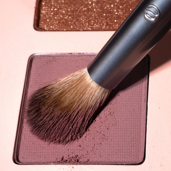Makeup brush with dense natural bristles and a metallic handle