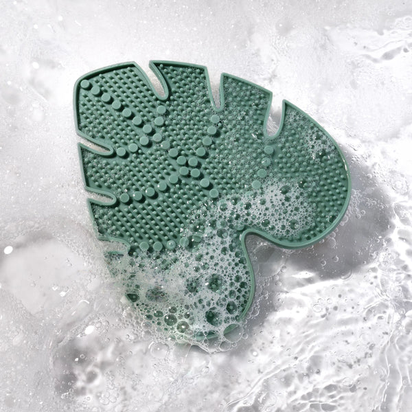 Makeup brush cleansing pad with suds, teal silicone brush-washing surface