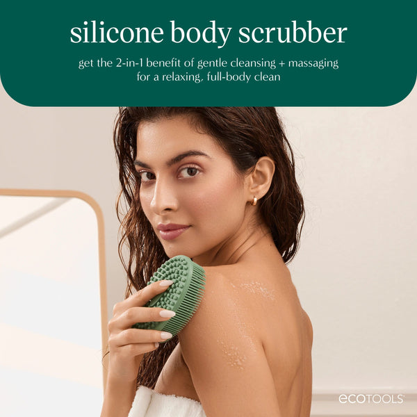 Sage green silicone body scrubber in hand with oval dot bristle face