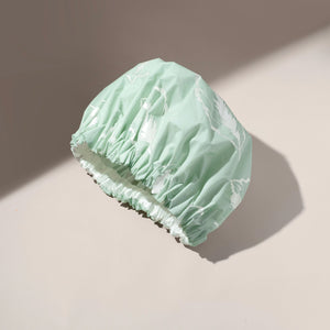 Mint XL shower cap with ruched elastic edge, folded for storage