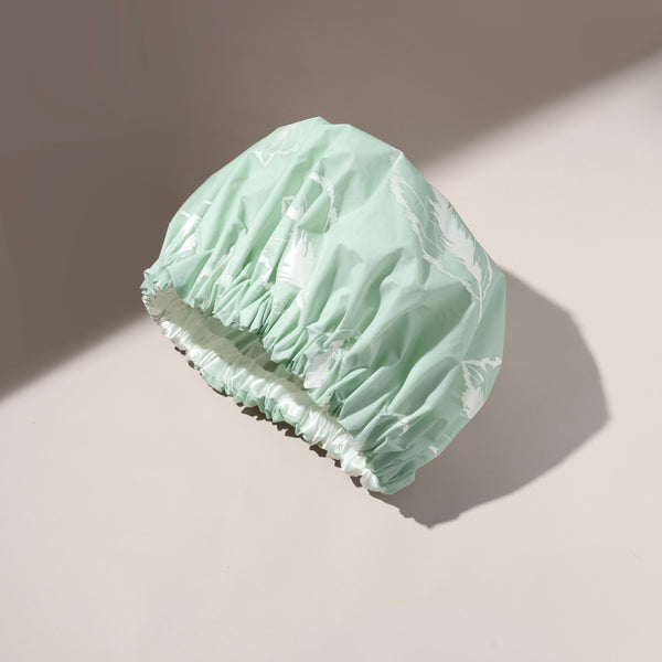 Mint XL shower cap with ruched elastic edge, folded for storage