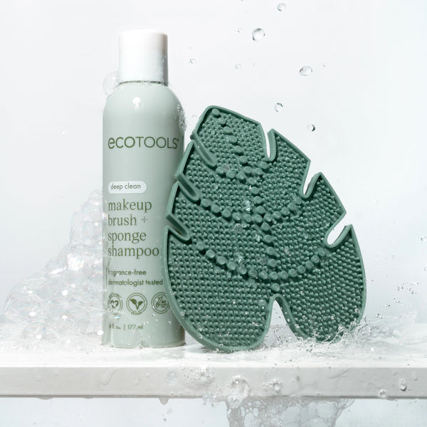 Green silicone makeup brush cleansing pad with soap bubbles and cleaning texture