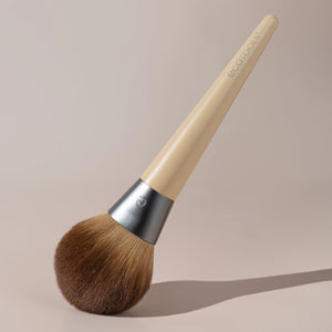 Powder blurring brush angled view with dark brown bristles and light bamboo handle