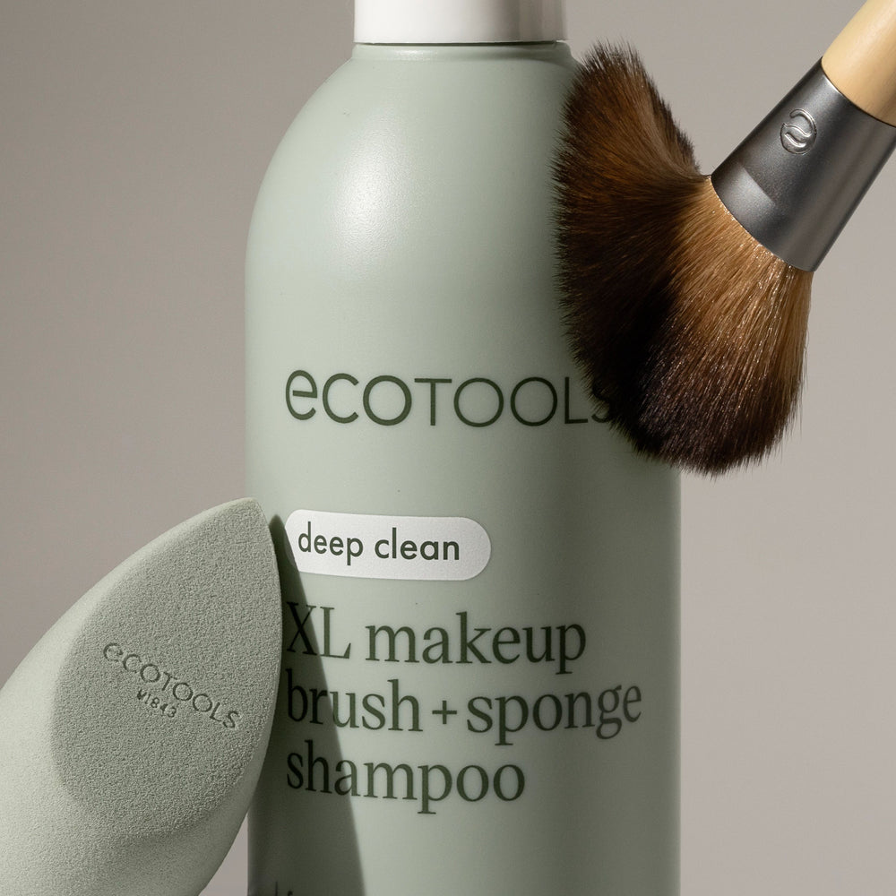 Sage-green ECOTools deep clean XL makeup brush + sponge shampoo bottle, front view