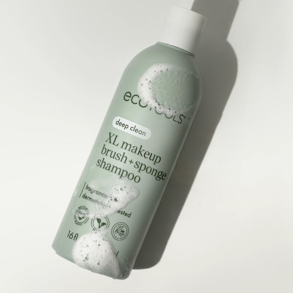 Sage-green ECOTools shampoo bottle with foam bubbles, deep clean XL label