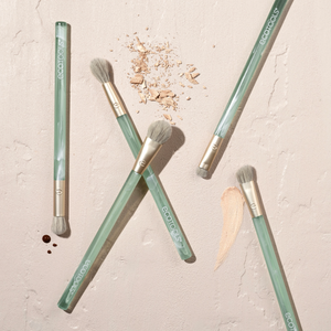 Sea Gems eye brushes laid out, five beige-bristle brushes with green clear handles