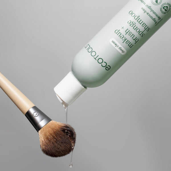 ECOTOOLS shampoo pouring onto makeup brush bristles from bottle