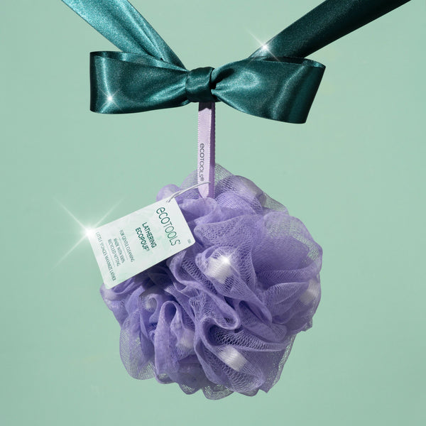Purple mesh lathering pouf with teal ribbon bow and hanging product tag
