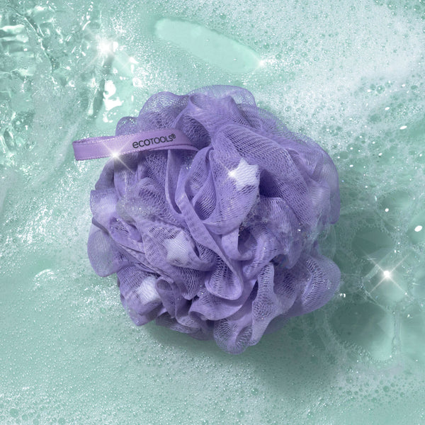 Purple lathering pouf floating in water with visible star sparkle