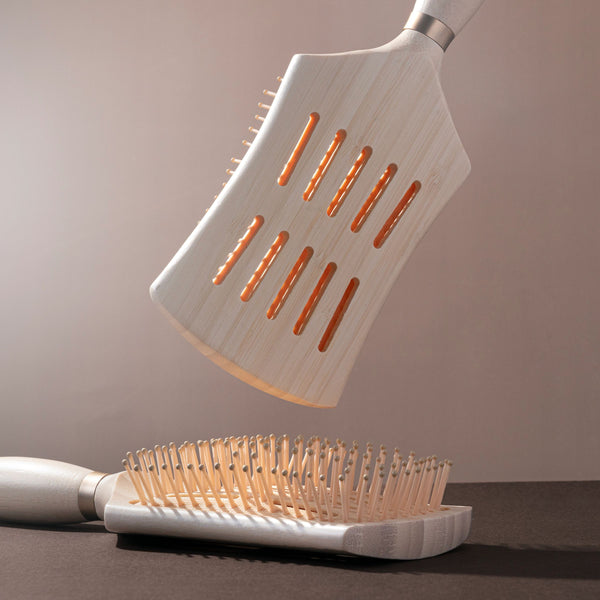Round-bristle detangling hair brush with light wood handle and heated/orange-tipped pins