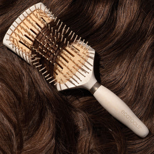 Smoothing detangler hair brush brushing dark hair, light wood handle and tan pin bristles