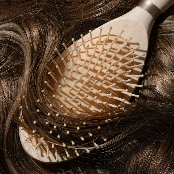 Close-up of detangling brush bristles against brown hair strands