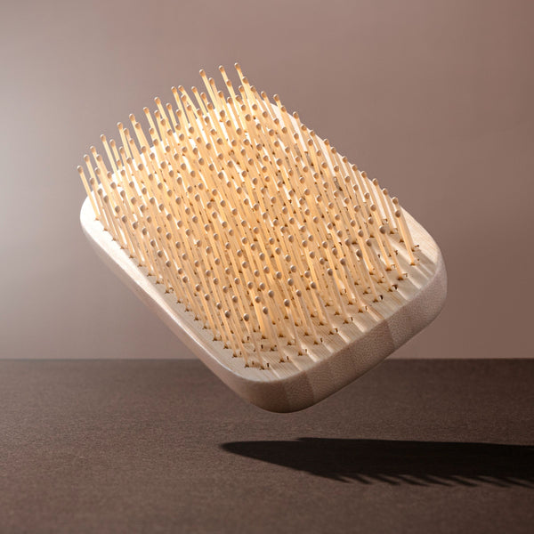 Light tan bamboo travel detangling hair brush with dense flexible pin bristles