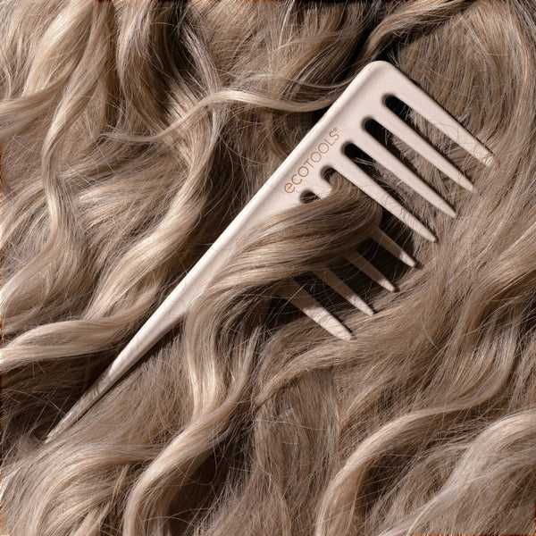 Wide tooth comb close-up gliding through blonde hair with wide teeth