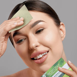 Facial blotting paper sheet held against the cheek for oil blotting
