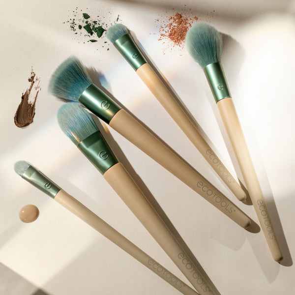 Teal-handled face makeup brushes arranged with bristles pointing upward