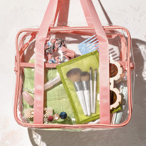 Makeup brush kit in clear bag with green pouch, pink strap, and 4 brushes.