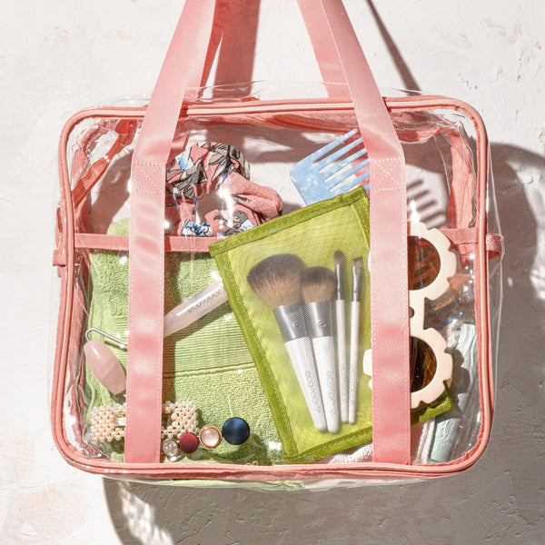 Makeup brush kit in clear bag with green pouch, pink strap, and 4 brushes.