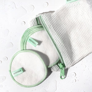 Set of reusable cotton pads with green edge stitching and mesh wash bag