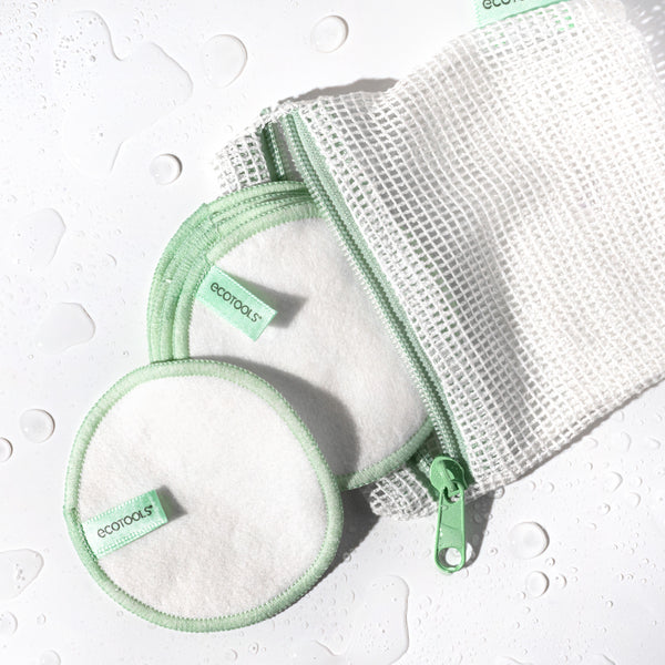 Set of reusable cotton pads with green edge stitching and mesh wash bag