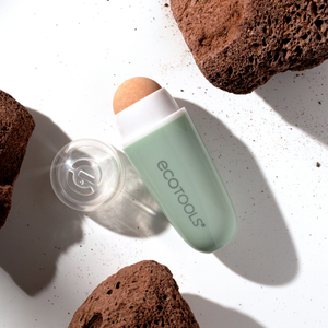 Oil-absorbing facial roller with mint-green base and clear stone roller head