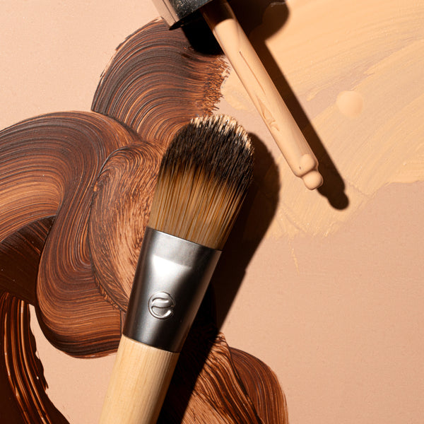 Close-up foundation brush with dense dark bristles on bamboo handle