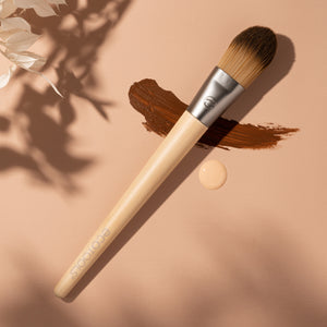 Angled foundation brush with dark bristles and light bamboo handle