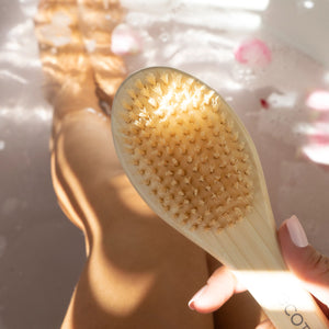 Wooden foot brush with tan bristle head and oval pumice stone insert