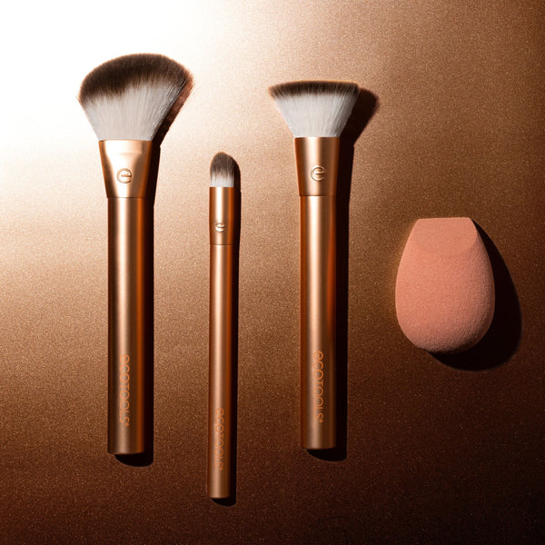 Three gold makeup brushes and teardrop blending sponge from the set.