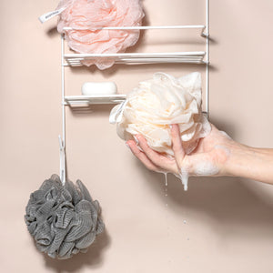 White mesh flower loofah bath sponge held in hand, with gray loofah nearby