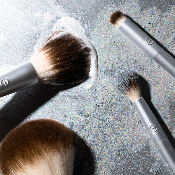 Silver makeup brushes with brown bristle heads for cheek and eye highlighting
