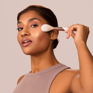 Makeup highlight brush blending shimmer on the cheek