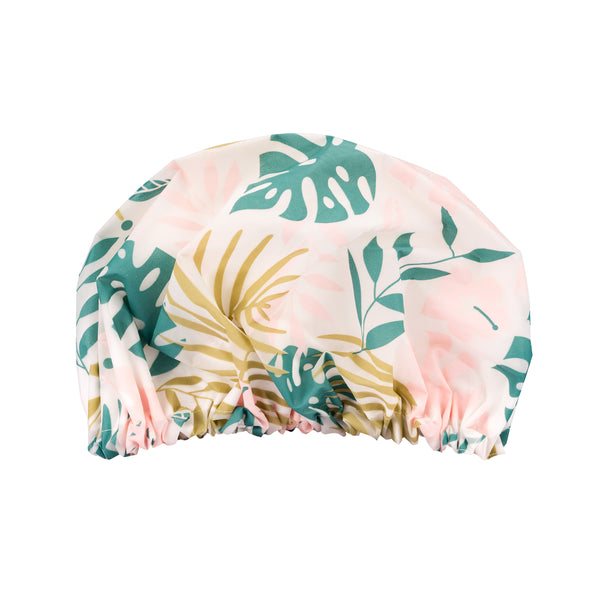 Printed shower cap with pink, green, and yellow tropical leaf pattern, elastic hem