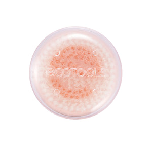 Pink round facial cleansing brush head with dense white bristles and orange center