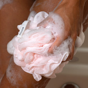 EcoPouf® bath sponge loofah, light pink ruffled mesh, held in hand