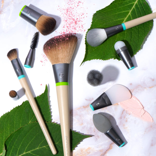Interchangeable makeup brush set with multiple gray bristle heads and visible makeup swatches