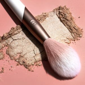 Soft highlight brush with fluffy bristles coated in glittery bronze powder